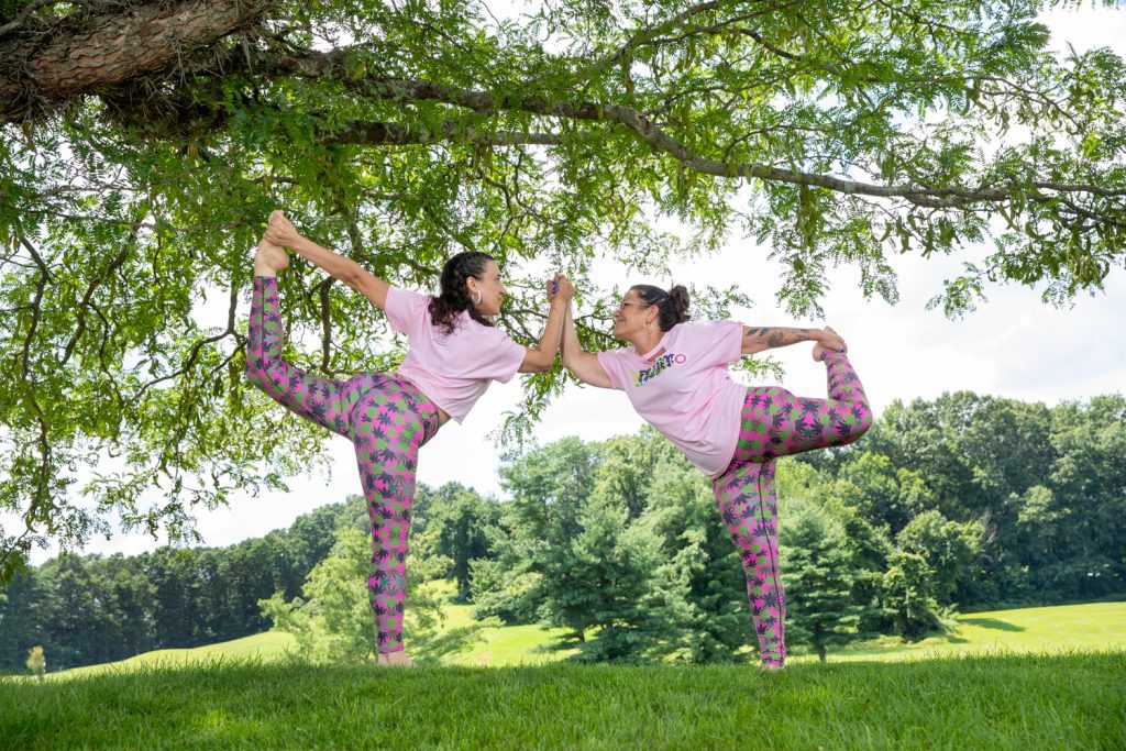 two girls holding hands doing a yoga pose