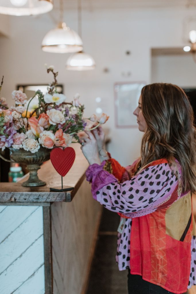 woman putting together a flower boutique in a kitchen