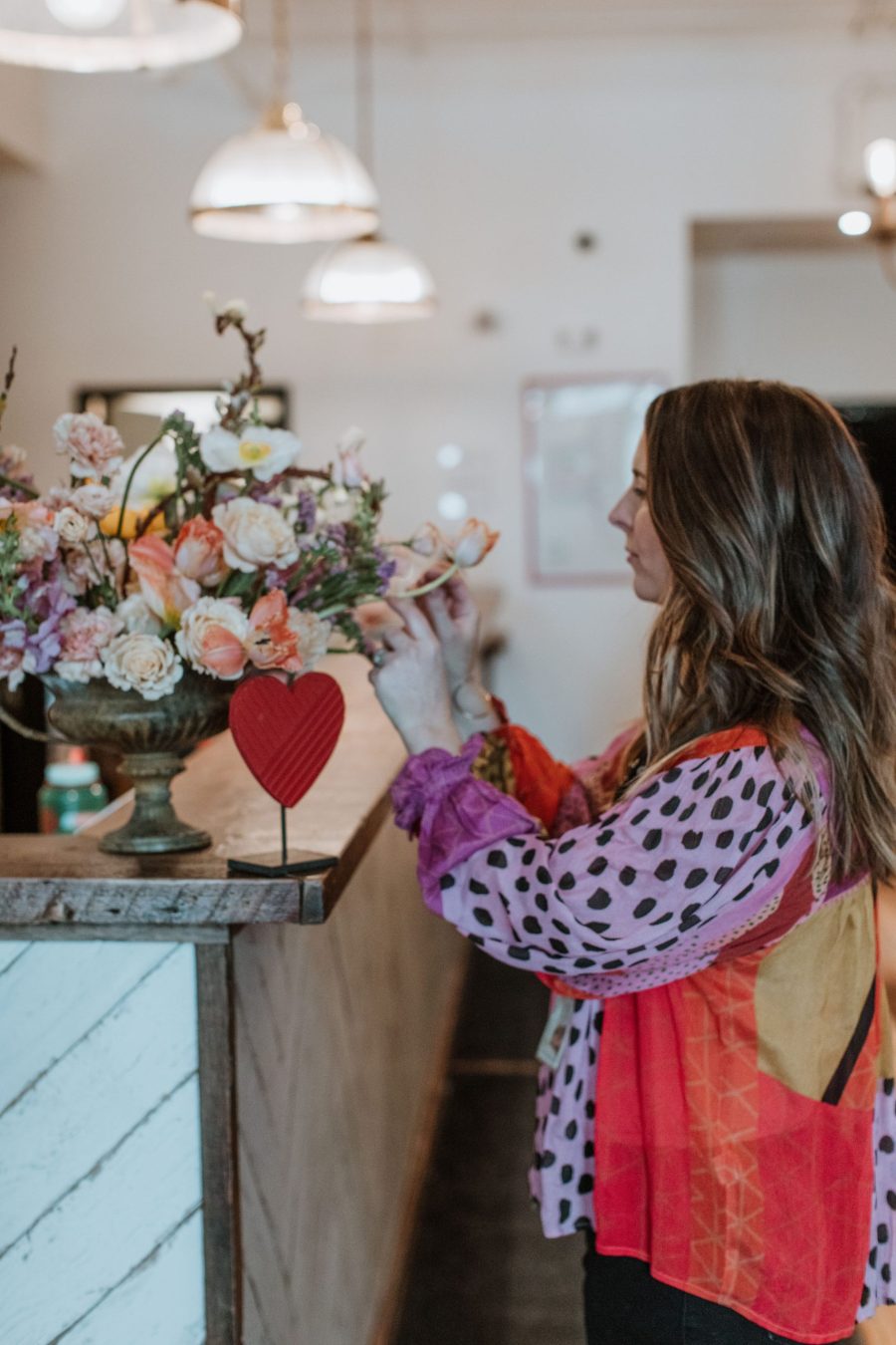 woman putting together a flower boutique in a kitchen